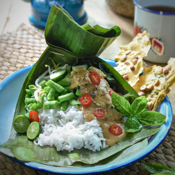 Siapkan nasi dalam pincuk daun pisang, masukkan sayuran, siram dengan sambal pecel, dan sajikan dengan rempeyek kacang.