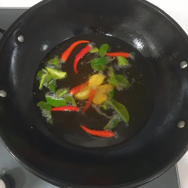 Goreng sebentar bawang putih, cabai rawit merah, dan daun jeruk purut. Angkat dan tiriskan
