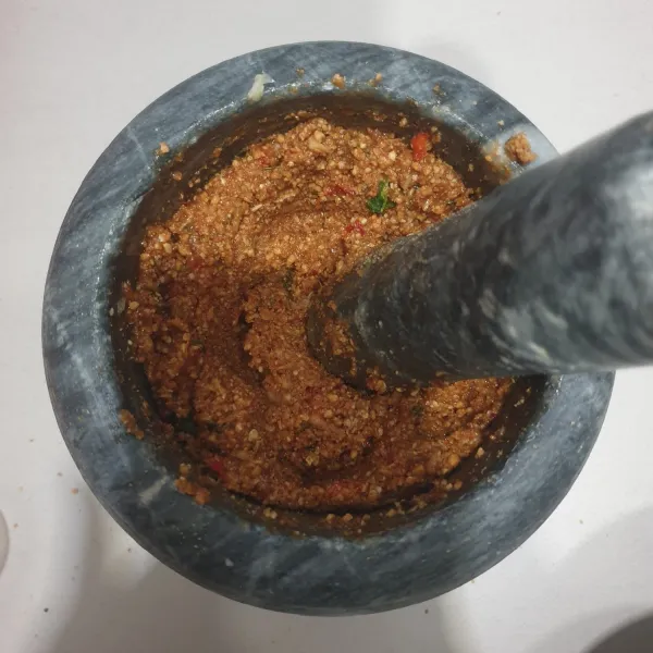 Masukkan kacang tanah goreng, tumbuk kembali hingga halus