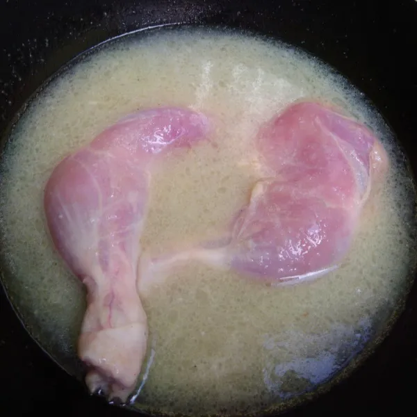 Tambahkan air kelapa, masukkan ayam. Ungkep hingga ayam empuk, matang, dan air menyusut.