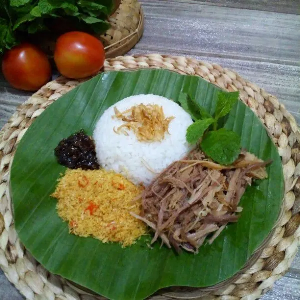 Sajikan nasi bersama daging suwir, serundeng kelapa, dan sambal petis.