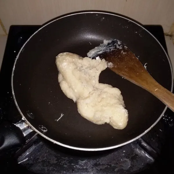 Setelah mendidih, kecilkan api. Masukan tepung terigu. Aduk hingga adonan kalis. Matikan api