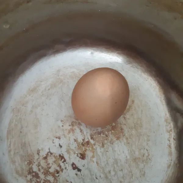 Rebus telur hingga matang. Angkat dan kupas.