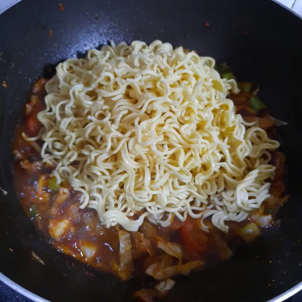 Masukkan mie telur. Masak sambil diaduk hingga mie dan bumbu tercampur rata.