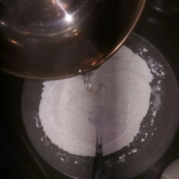 Campur tepung beras, garam dan minyak wijen dalam satu wadah, aduk hingga ketiganya tercampur rata. Lalu tuang air panas sedikit demi sedikit sambil aduk adonan menggunakan sendok kayu.