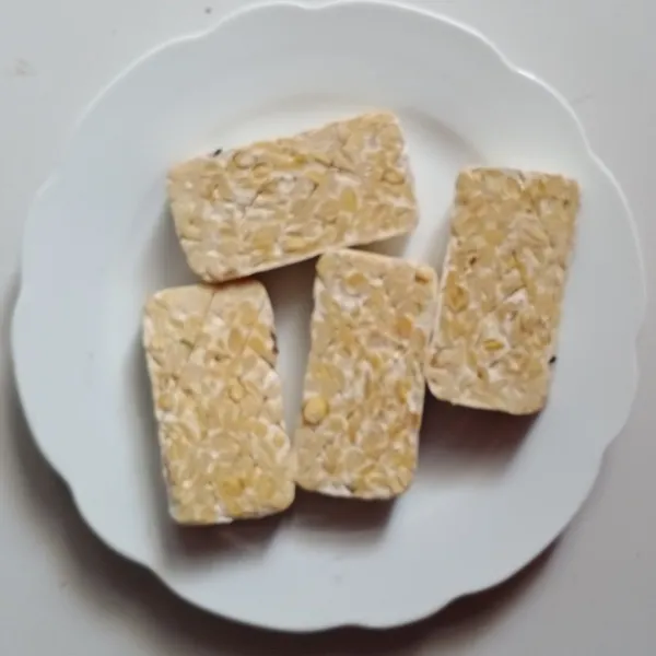 Potong-potong tempe setebal 2 cm, iris tengahnya.