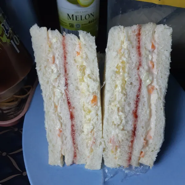 Bungkus sandwich dengan plastik wrap kemudian simpan dalam lemari pendingin selama 30 menit. Setelah itu, potong menjadi 2 bagian dan siap dinikmati.