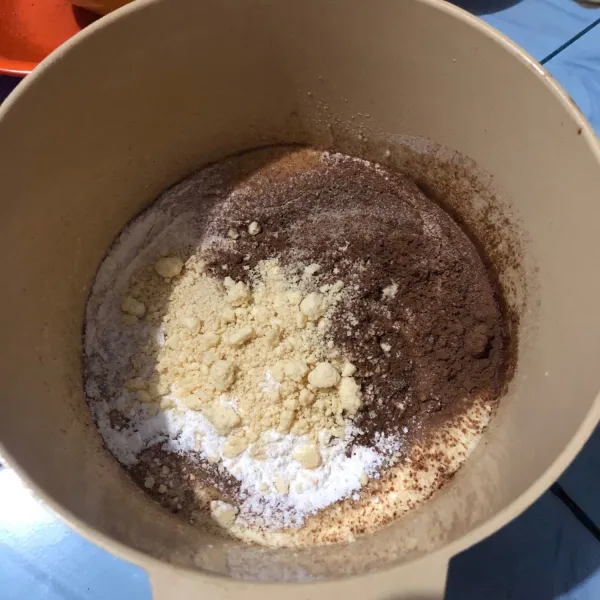 Tambahkan tepung terigu, susu bubuk, tepung maizena, dan cokelat bubuk ke dalam adonan sebelumnya. Lalu aduk dengan spatula hingga rata