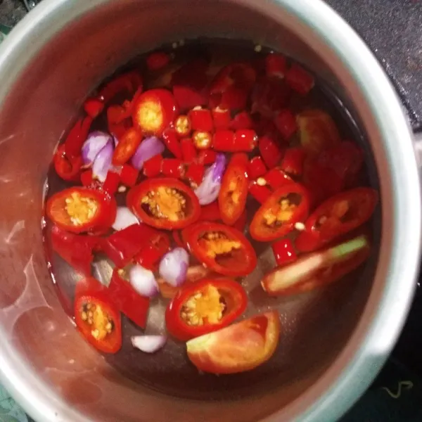 Buat sambal lambok. Iris bawang merah, cabe merah dan cabe keriting. Didihkan air, rebus 5 menit, tiriskan.