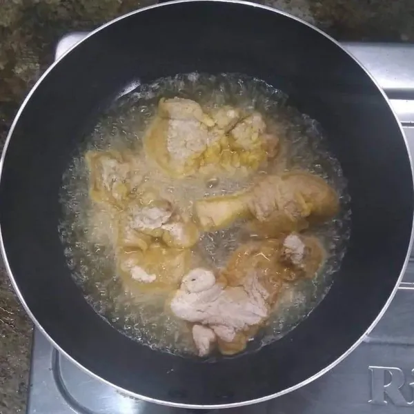 Goreng daging ayam tepung dalam minyak panas.