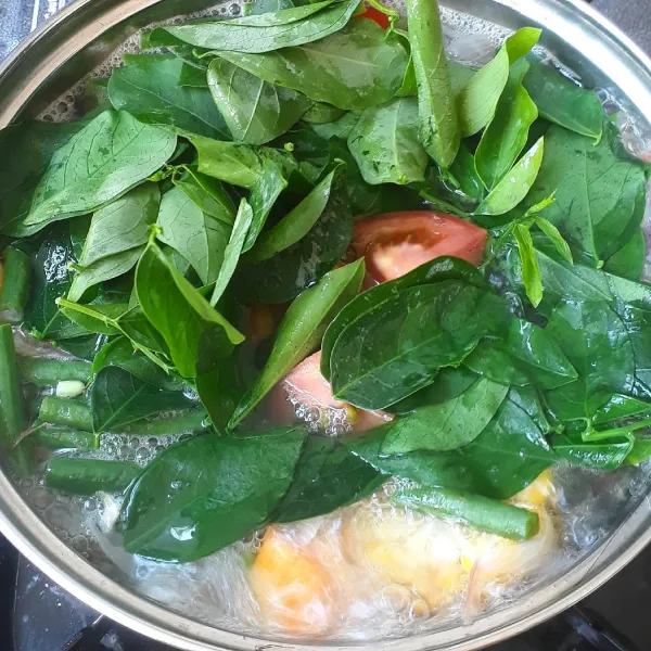 Masukkan daun katu dan tomat. Masak beberapa saat hingga daun katu layu.