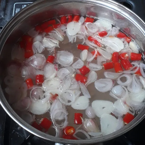 Didihkan api lalu masukkan irisan bawang putih, bawang merah, cabai merah besar, asam, dan terasi bakar. Masak beberapa saat hingga aroma bumbu keluar