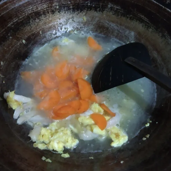Tambahkan air dan wortel. Masak sampai wortel setengah matang.