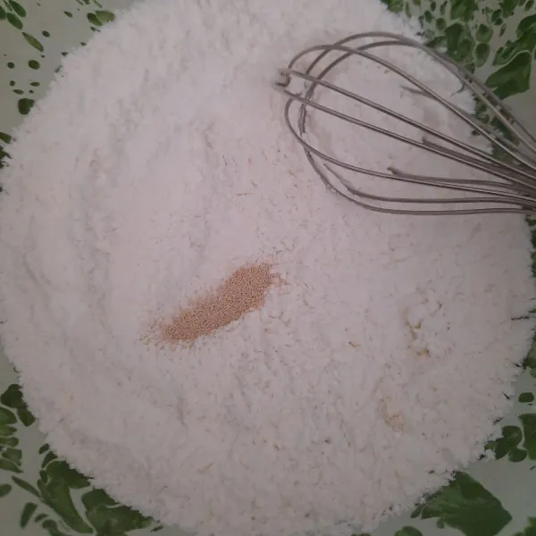 ayak semua tepung, campurkan dengan ragi. aduk rata.
