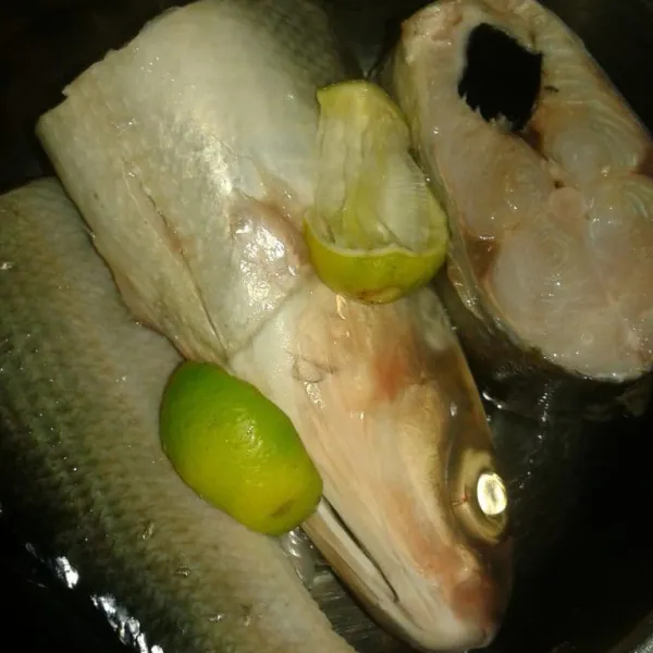potong ikan menjadi 3 bagian. Lumuri dengan perasan air jeruk nipis dan sedikit garam. diamkan sebentar, lalu cuci bersih