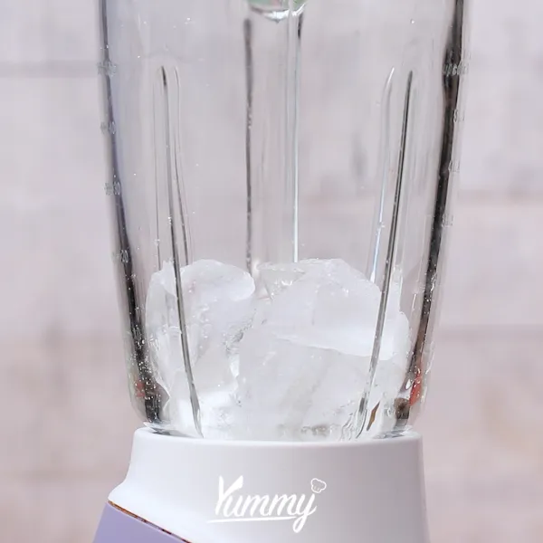 Siapkan blender lalu masukkan es batu dan es krim vanila ke dalamnya.
