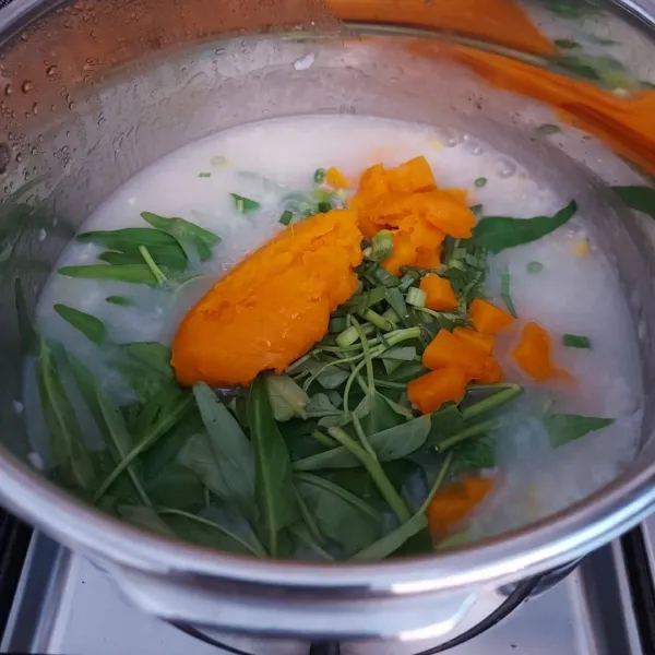 Masukkan kangkung, daun bawang, daun kunyit dan labu kabocha, aduk rata. Masak sampai sayuran matang.