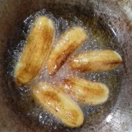 Panaskan minyak goreng dalam wajan. Goreng pisang hingga matang kecoklatan.