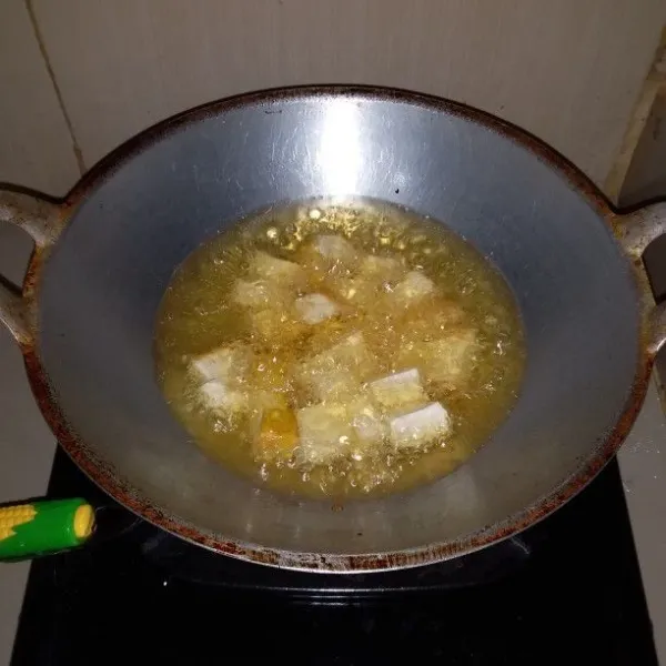 Cuci dan potong dadu tahu kuning. Kemudian goreng hingga kering. Angkat dan tiriskan