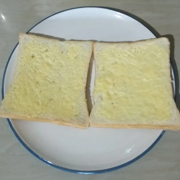 Oles margarin ke semua permukaan roti (bulak balik diberi margarine).