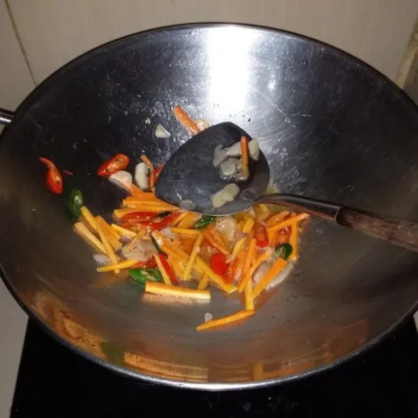 Panaskan minyak goreng. Tumis bumbu rajang hingga harum. Masukkan wortel dan air. Masak hingga wortel empuk.