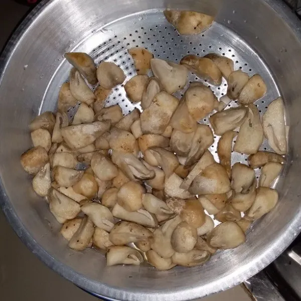 Belah jamur kancing menjadi 4 bagian. Cuci dan tiriskan
