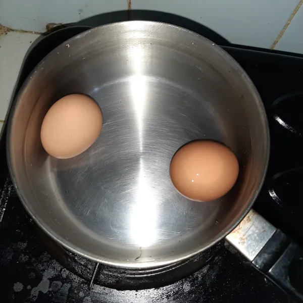 Rebus telur lalu kupas kulitnya.