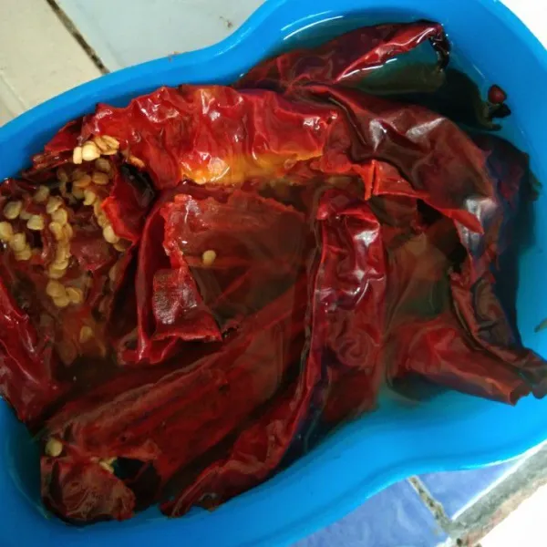 Rendam cabe merah kering dengan air panas buang bijinya, biarkan dingin cuci cabe dan tiriskan.