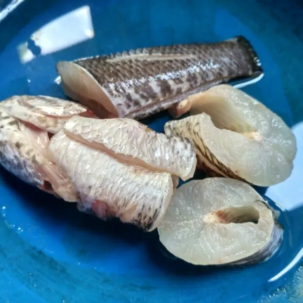 Bersihkan ikan gabus dan potong-potong, lalu cuci bersih.