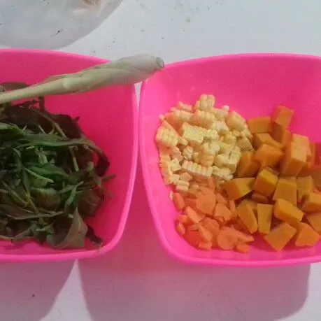 Siapkan bahan sayuran. Petik daun kangkung. Iris tipis wortel, sisir jagung manis dan potong dadu labu kuning.