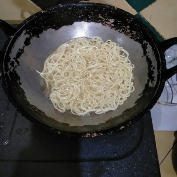 Goreng mie dengan 250 ml minyak goreng di api sedang. Angkat.