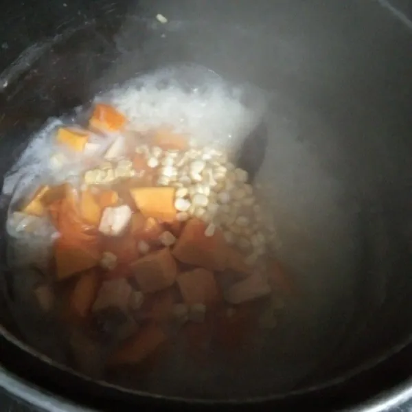 Masukkan jagung, ubi dan labu. Masak hingga umbi matang. Beri air lagi.