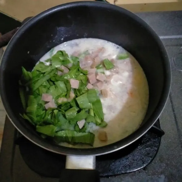 Masukkan 200 ml air, bakso dan sawi hijau. Aduk rata.