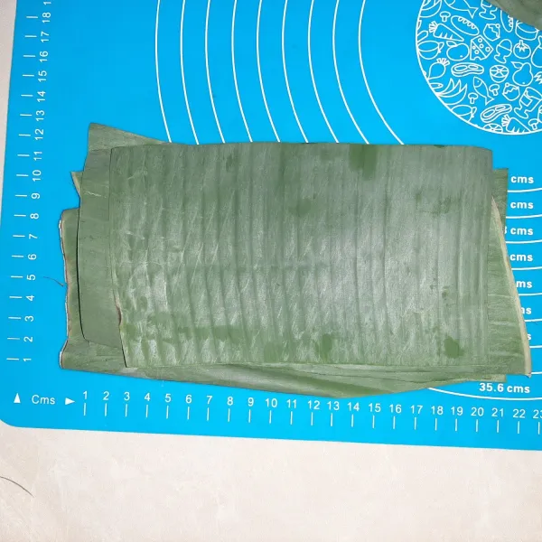 Siapkan daun pisang. Saya buat 20 x 10 cm. Tapi kalau daun pisangnya besar, dibuat lebih besar akan mempermudah pengisian, yang penting bentuknya persegi panjang.