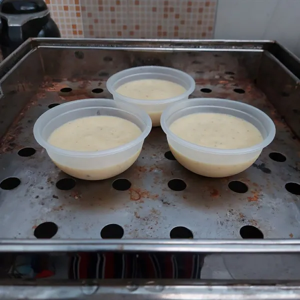 Masukkan lapisan pisang ke wadah sebanyak ¾ bagian tinggi wadah. Kukus ±25 menit dengan api sedang. Lapisi tutup kukusan dengan serbet.