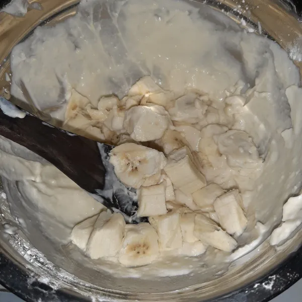 Buat lapisan tengah : potong-potong pisang dan masukkan ke sisa adonan lapisan bawah.