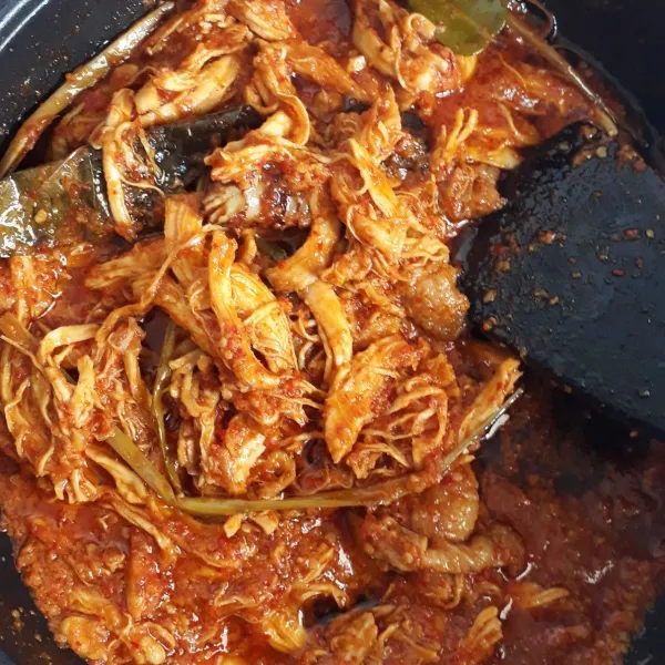 Masak ayam suwir dengan api cenderung kecil hingga bumbu mengental dan air benar-benar hilang. Cek rasa lalu matikan api.