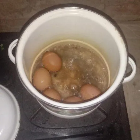 Rebus telur sampai matang. Angkat dan kupas kulitnya.