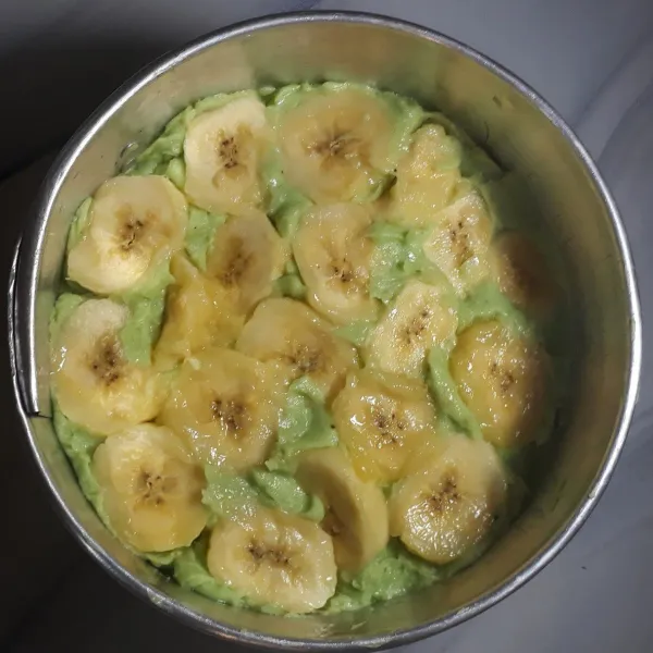 Letakkan irisan pisang di atas adonan tepung dengan agak ditekan.