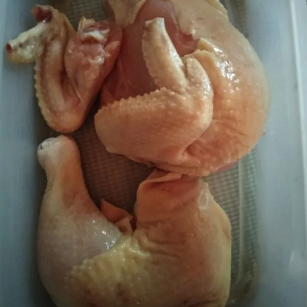 Pertama bersihkan ayam, potong menjadi dua bagian.