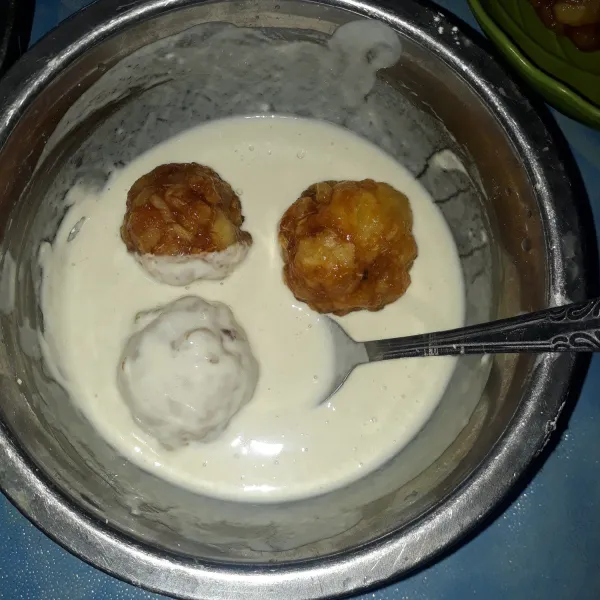 Celupkan singkong yang sudah dibentuk bulatan tadi ke dalam adonan bahan pelapis sampai rata.