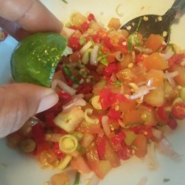 Campurkan semua bahan sambal matah. Beri gula dan garam. Tambahkan air jeruk limo, lalu aduk.