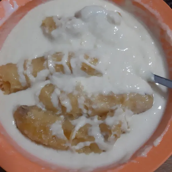 Masukkan air sedikit demi sedikit dan pisang sambil dibejek-bejek supaya pisang hancur kasar. Tekstur adonan kental dan mudah dituang.