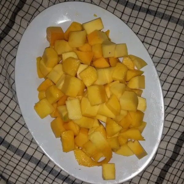 Kupas dan cuci buah mangga kemudian potong dadu
