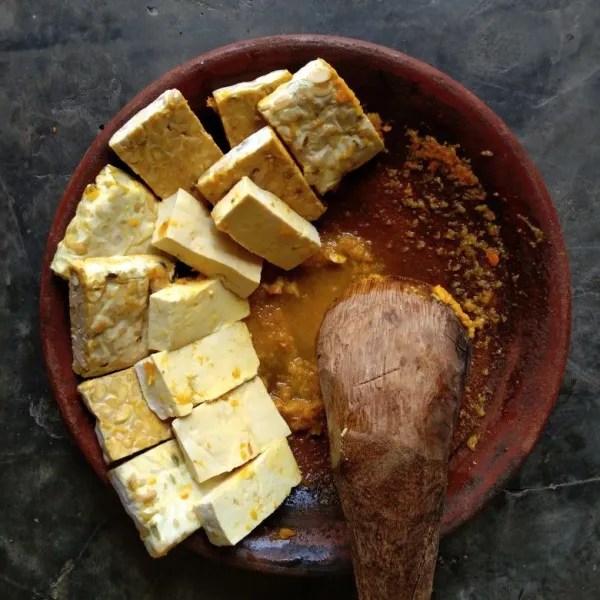 Haluskan 3 buah bawang putih, seujung jari kunir, 1 sdt garam, 1 sdt ketumbar dan sedikit air. Potong tempe dan tahu sesuai selera dan celup tempe dan tahu dalam bumbu.