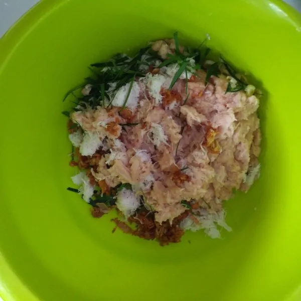Campur daging giling di wadah campur dengan bumbu halus dan daun jeruk.