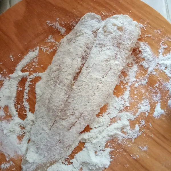 Siapkan tepung bumbu lalu baluri ikan dengan tepung, bolak balik.