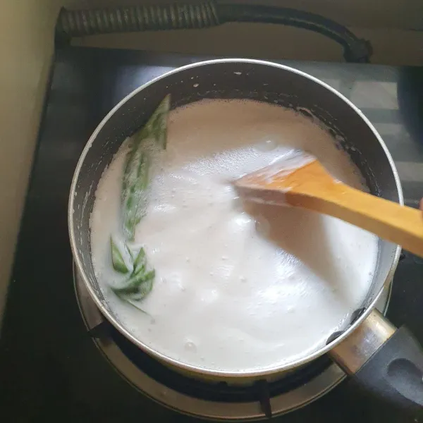 Campur tepung beras, gula dan garam dengan 300 ml air. Didihkan santan sisa bersama daun pandan.