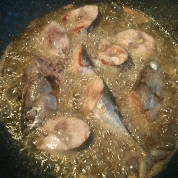 Goreng ikan tongkol dalam minyak panas sampai matang kecoklatan.