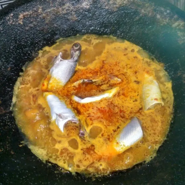 Masukkan air, serai, lengkuas dan daun jeruk. Tunggu hingga mendidih dan masukkan ikan.